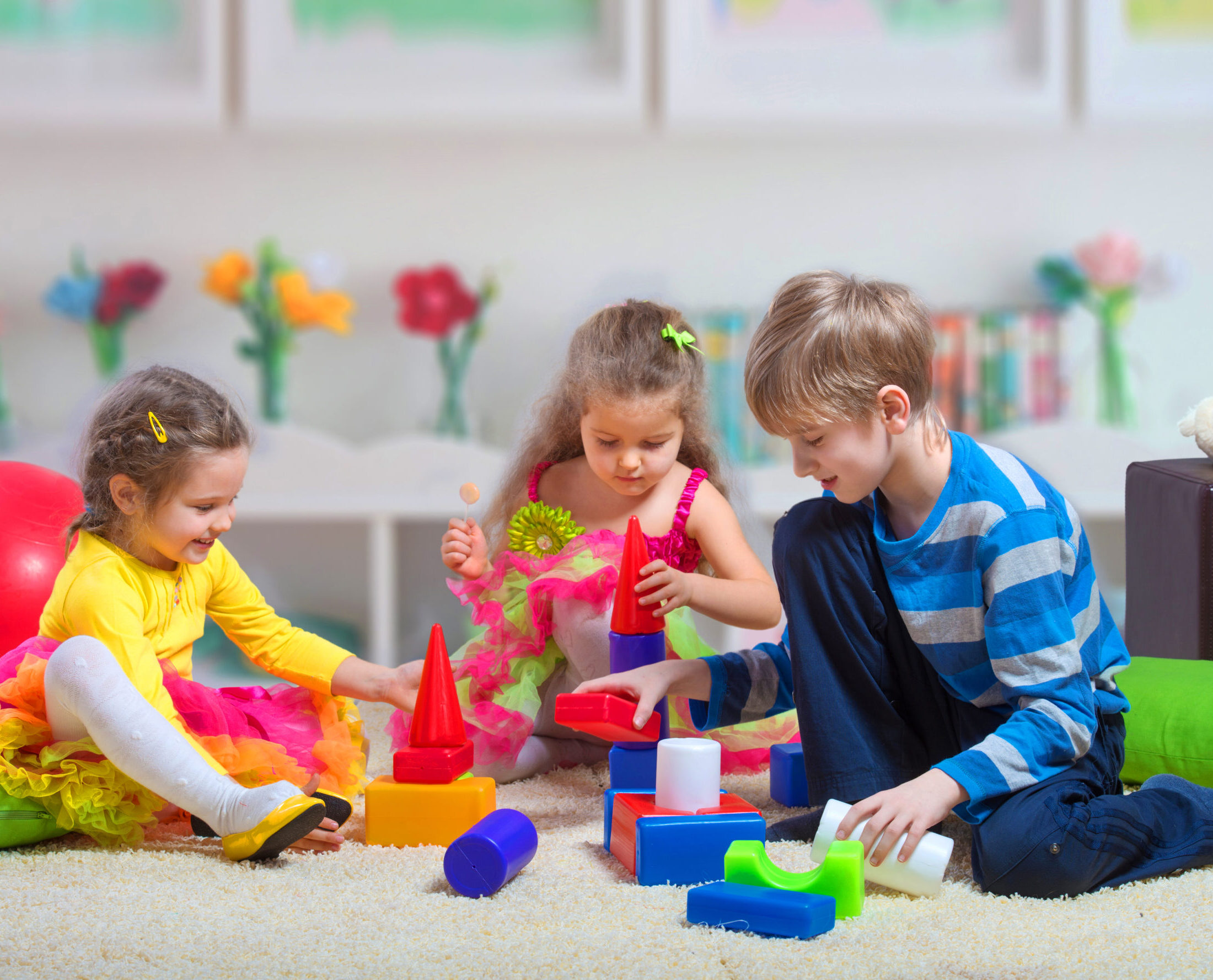 Preteen boy playing with two younger girls