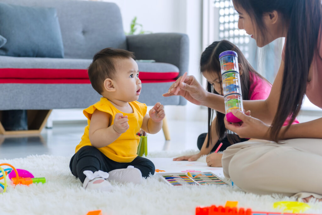 happy baby sitting on the floor at a daycare in Pimple Saudagar